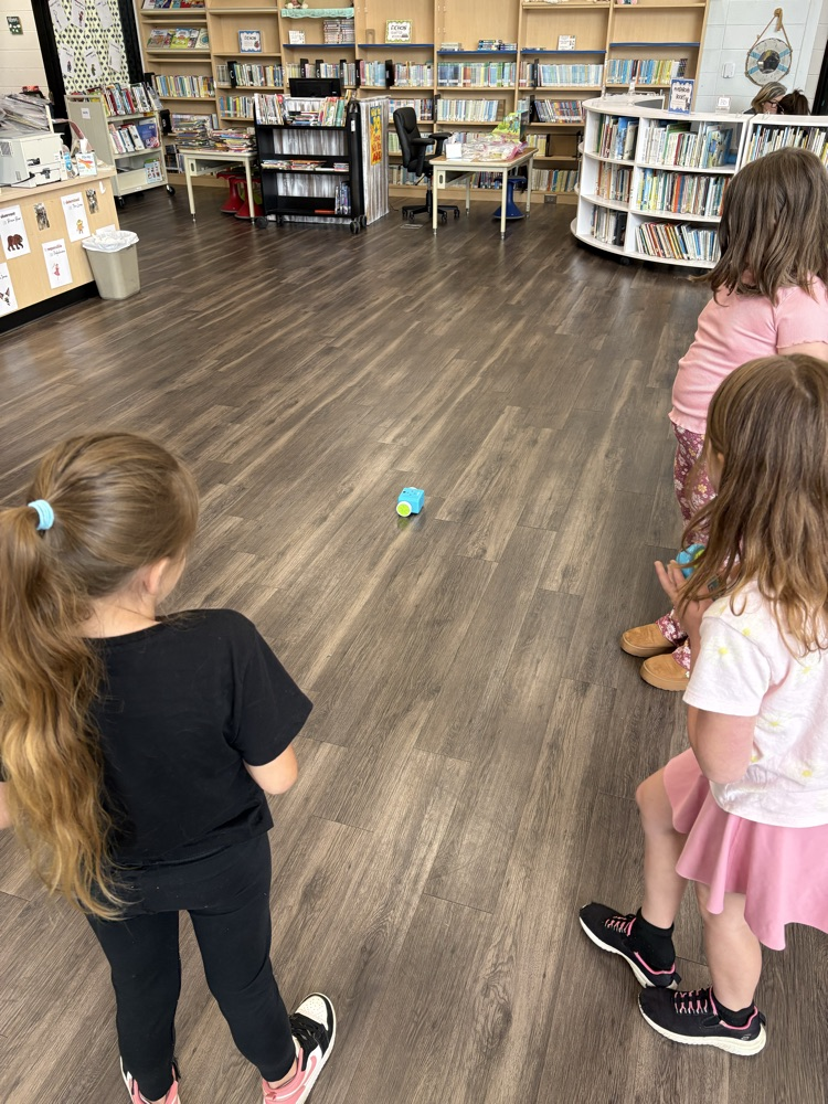 Students used a remote to code a new robot in the library. 