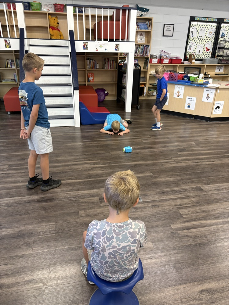 Students used a remote to code a new robot in the library. 