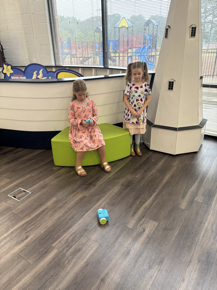 Students used a remote to code a new robot in the library. 