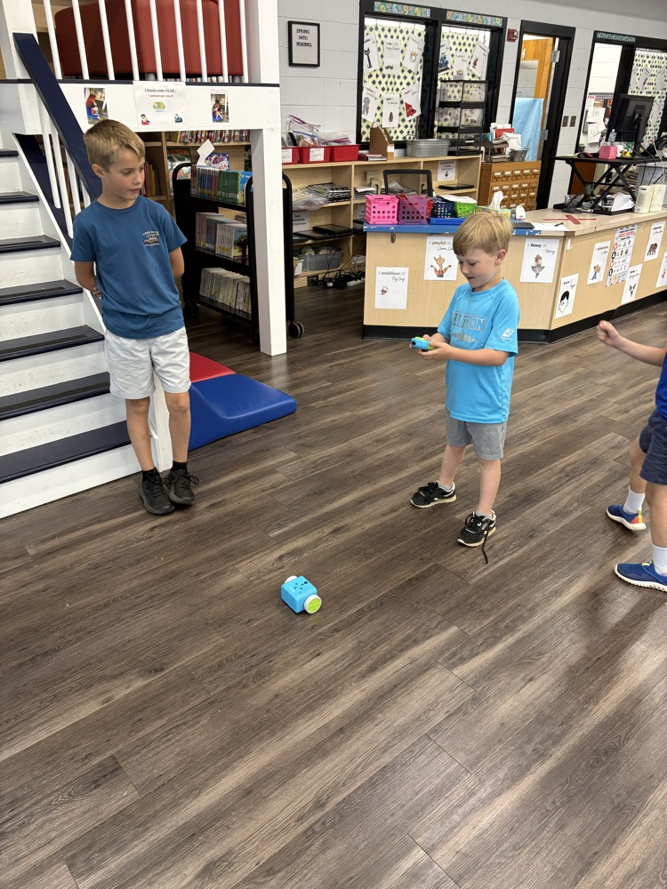 Students used a remote to code a new robot in the library. 