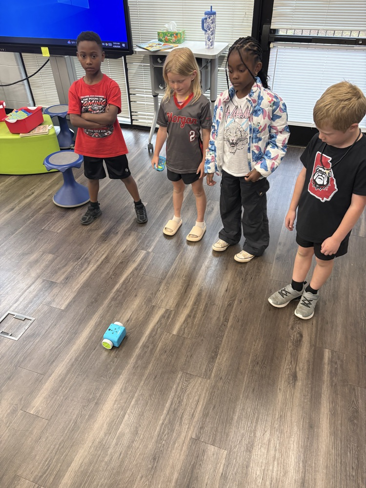Students used a remote to code a new robot in the library. 