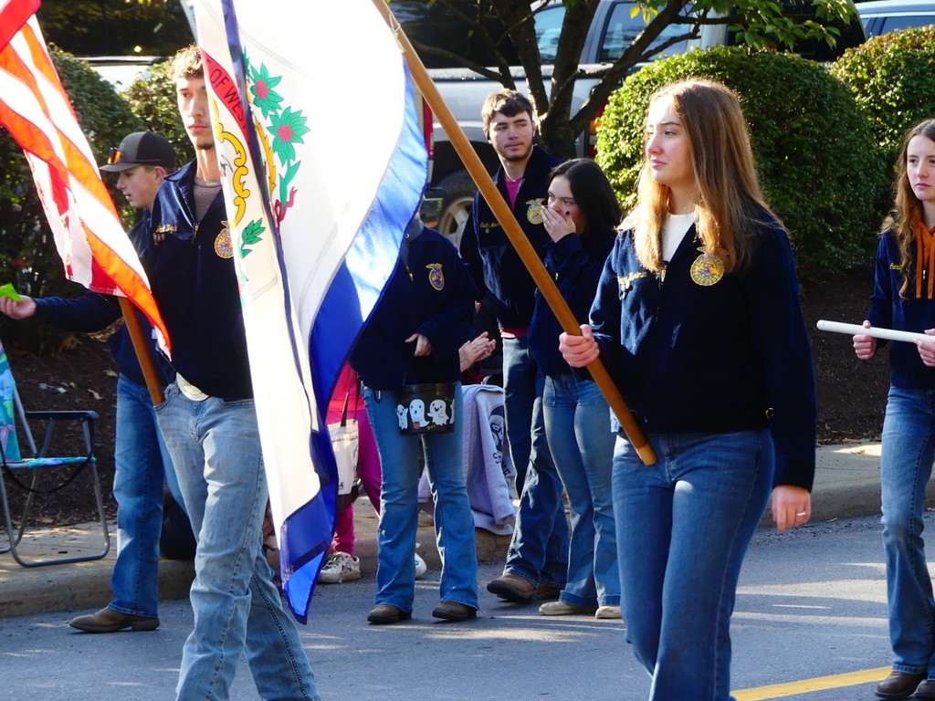 FFA members Janine Hartman and Jacob Boyce holding flags in the Apple Butter parade.
