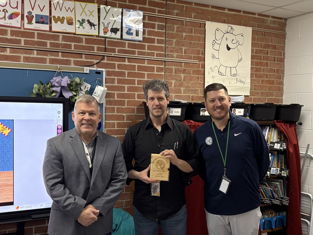 Three staff members holding an award.