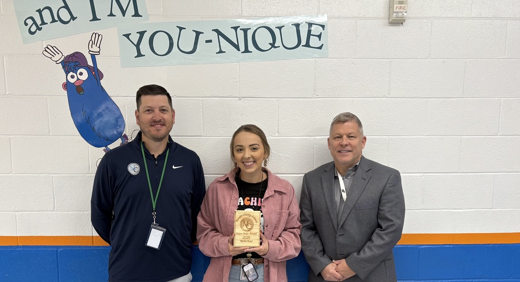 Three staff members holding an award.