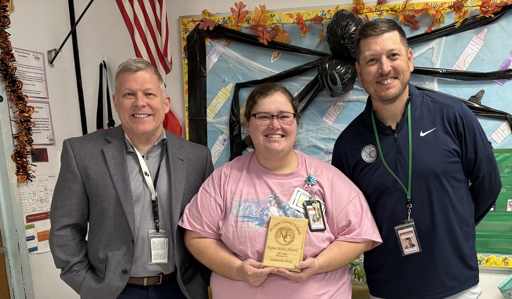 Three staff members holding an award.