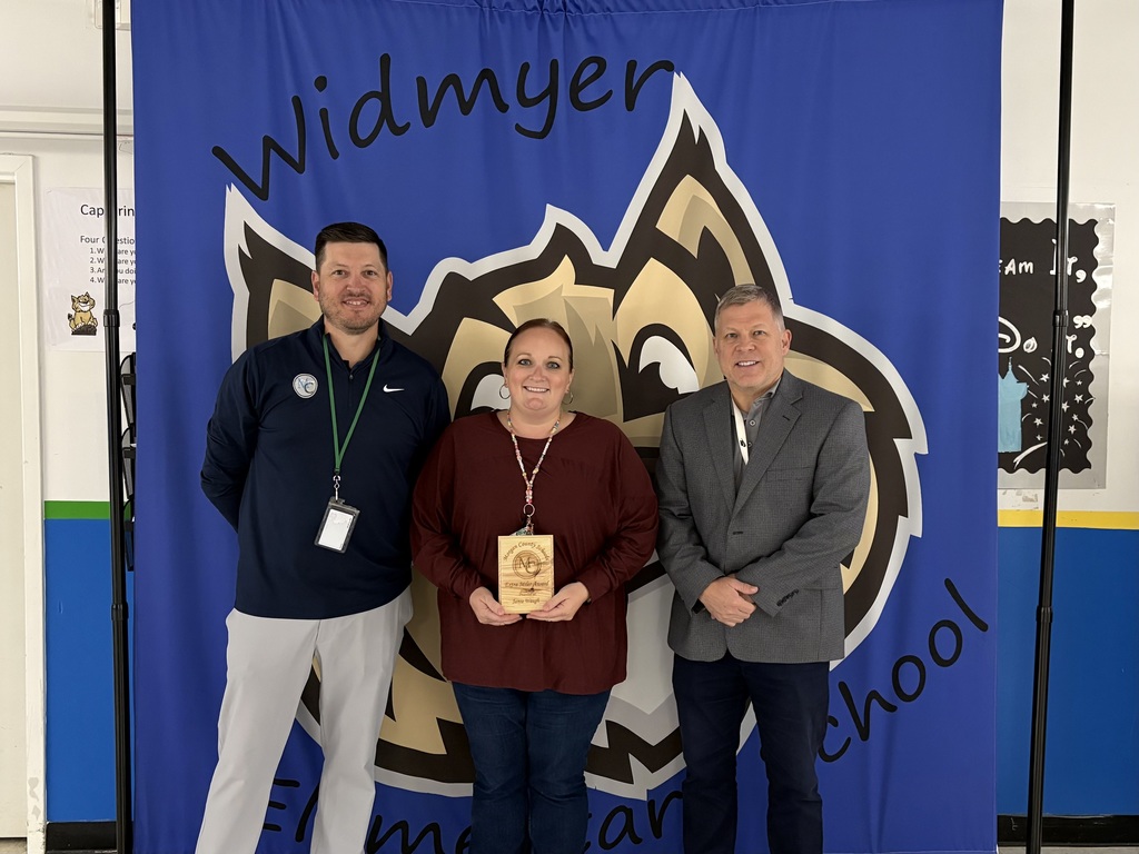Three staff members holding an award.