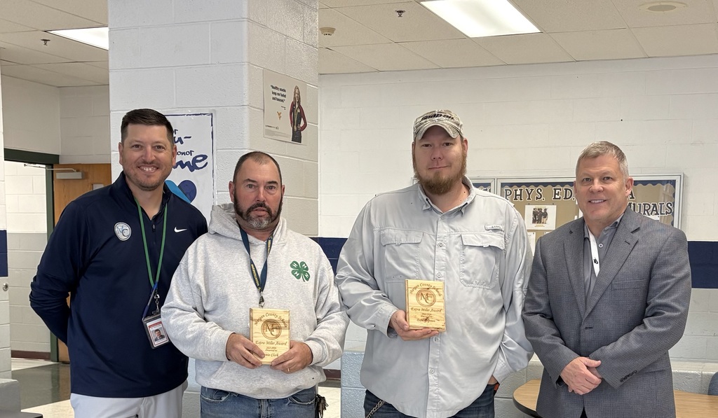 Three staff members holding an award.