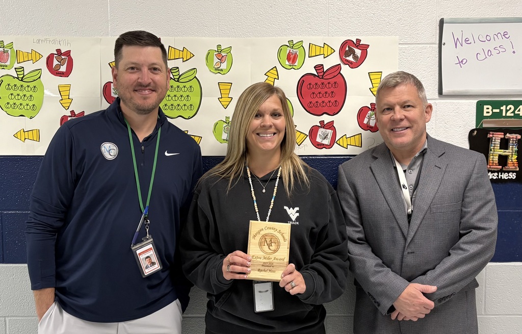 Three staff members holding an award.