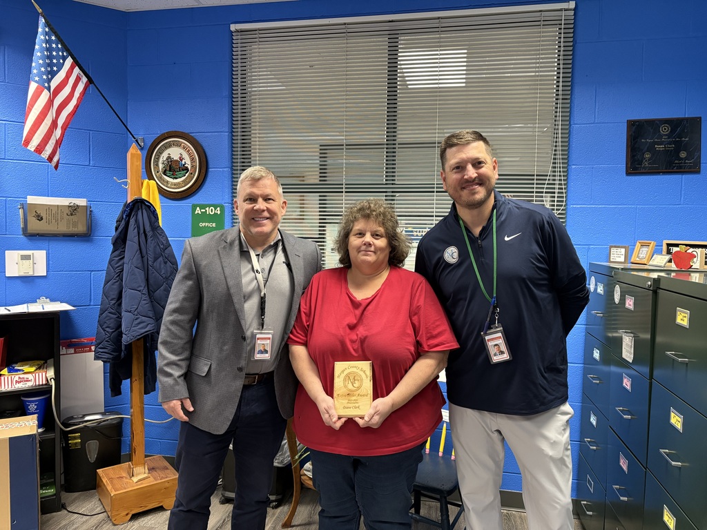 Three staff members holding an award.