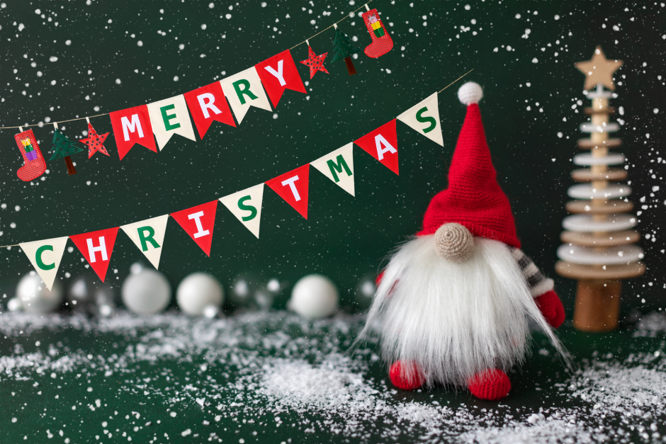 Festive gnome and tree with snow and a banner that reads “Merry Christmas.”