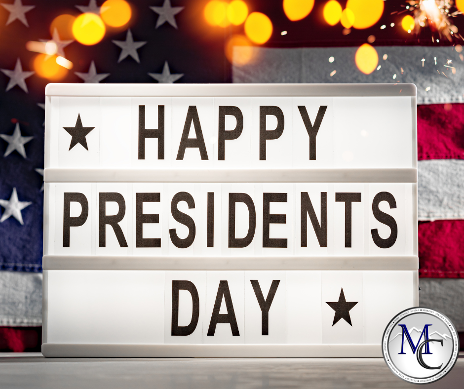 Lighted sign reading “Happy Presidents Day” with an American flag background.