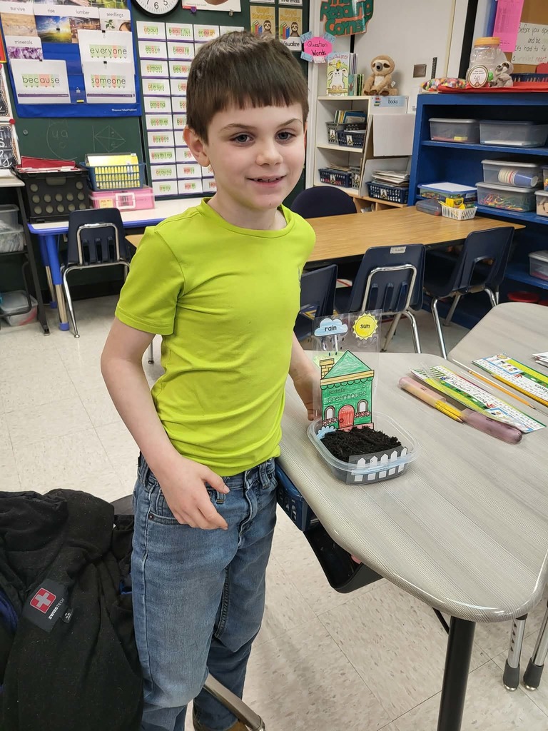 Student standing beside his house and garden model