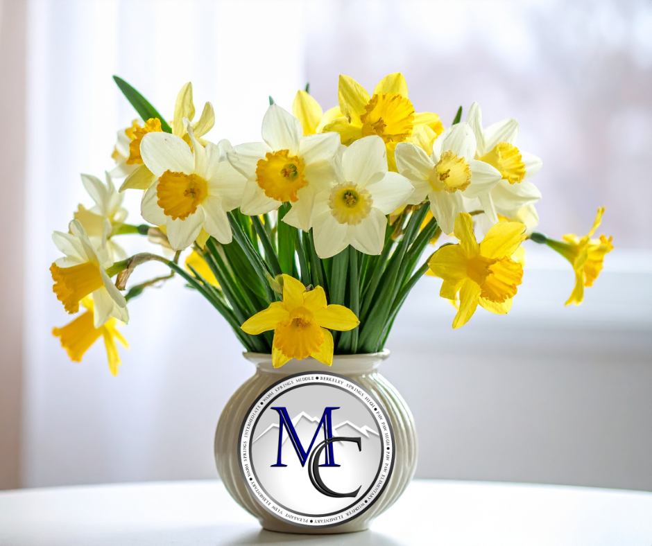 Vase of yellow and white flowers with MCS logo