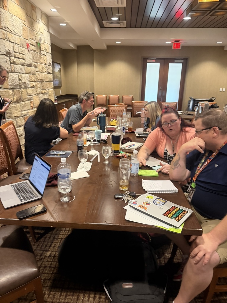 Multiple staff members at a table during admin academy.