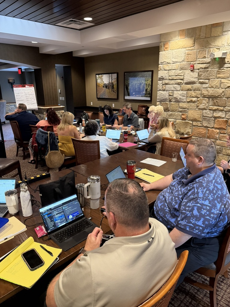 Multiple staff members at a table during admin academy.