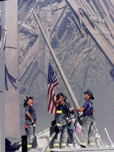 Firefighters raise the American flag over the site of the 9/11 attacks in Washington, D.C.