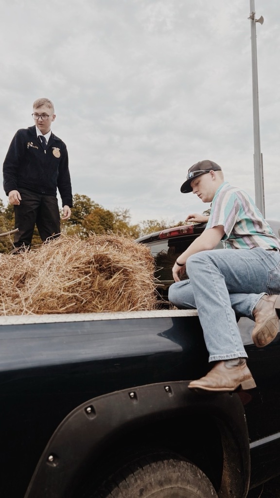 two members cleaning up hay 