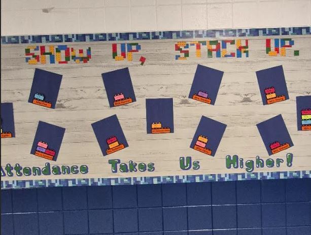 School attendance display with blocks and “Attendance Takes Us Higher!”