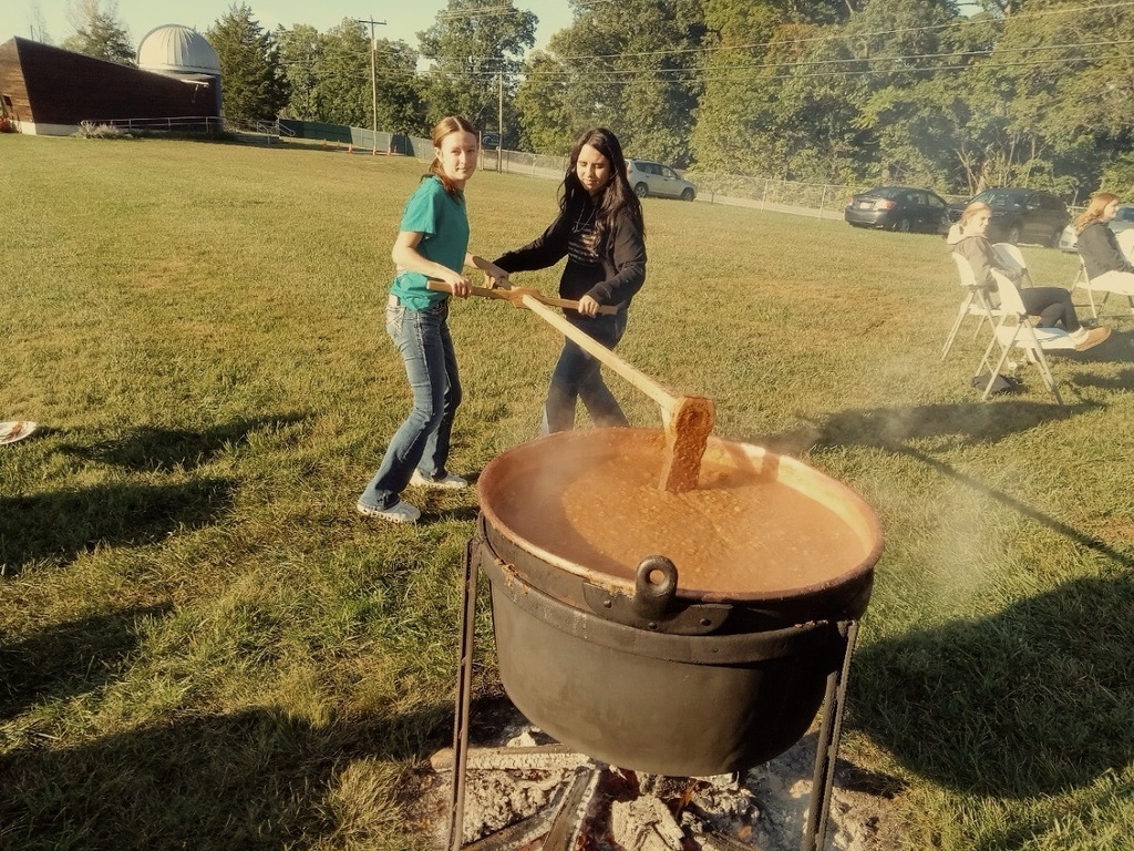 two girls stirring apple butter