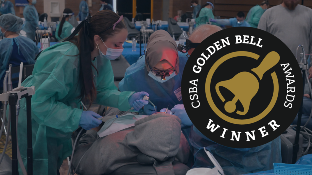 golden bell decorative photo showing students giving dental work at event