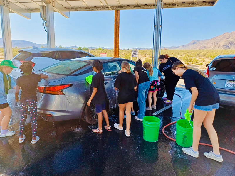 alumni and student leaders working together washing cars