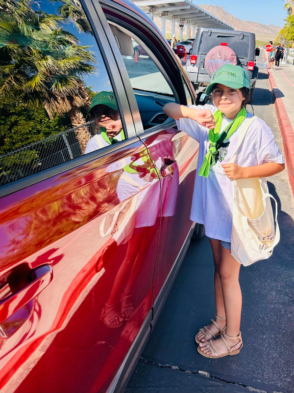 Pebbles Garcia student leader greeting cars as they pull in