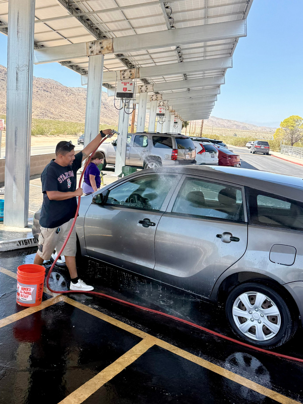 Mr. De La Puente rinsing off a car supporting our car wash