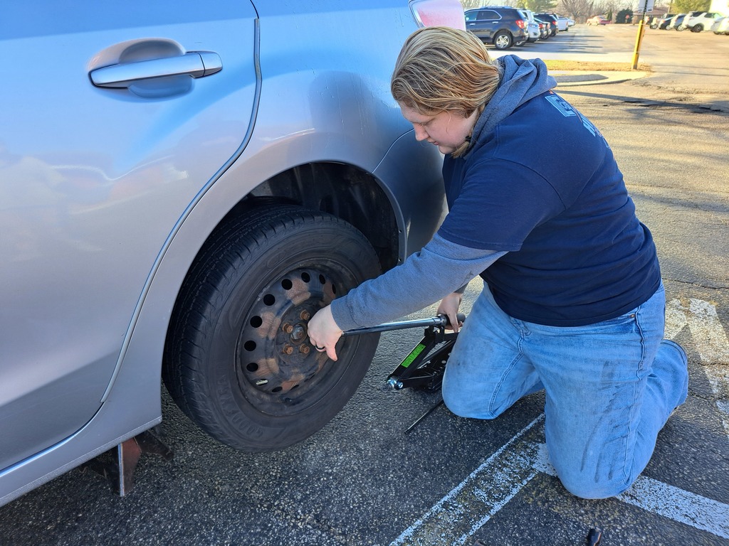 Natalie Seilhymer changes a tire as part of a demonstration in Driver Education at Morrison HS. 