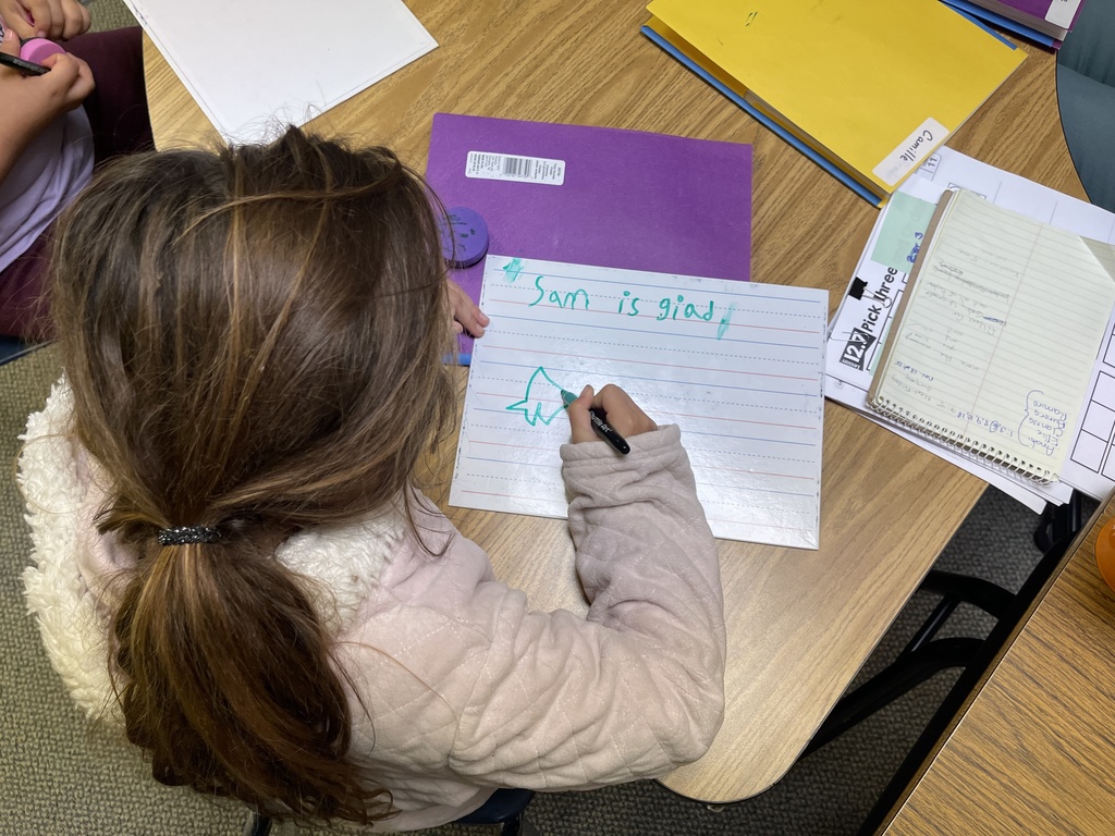 student writes on whiteboard
