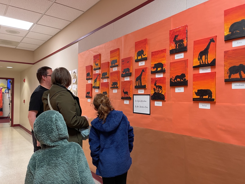A family observes paintings of animals