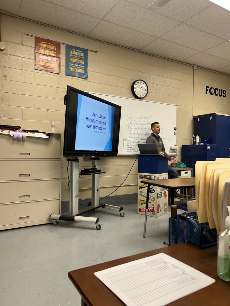 school board member teaching ag students about the laser engraver