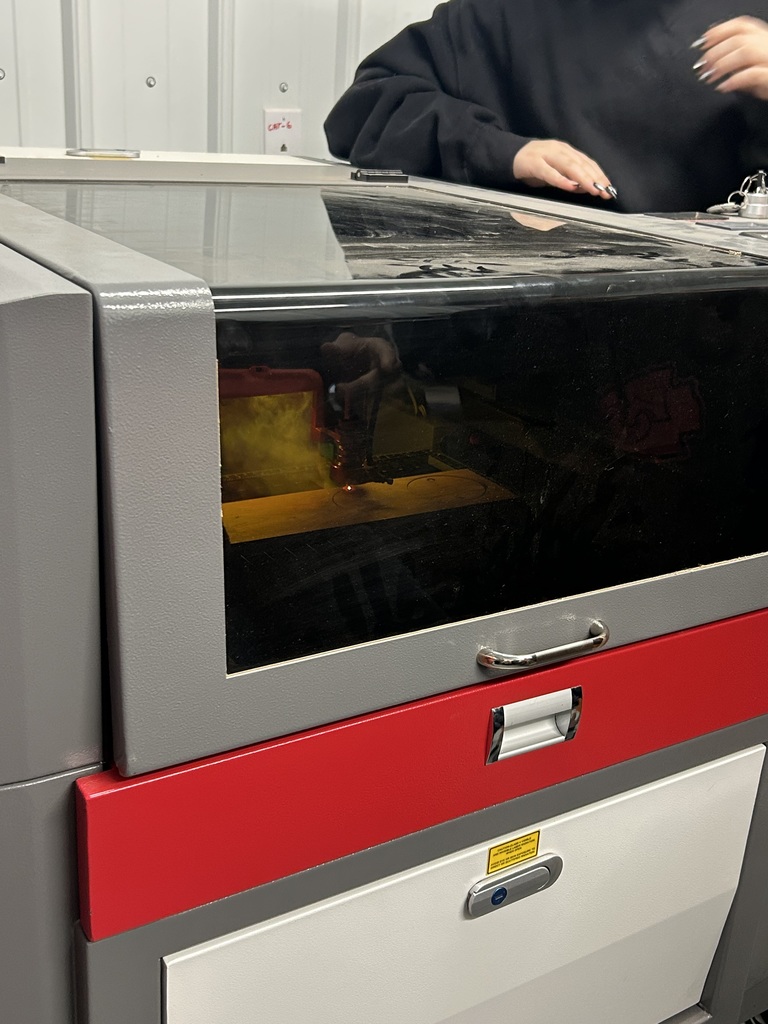 school board member teaching ag students about the laser engraver