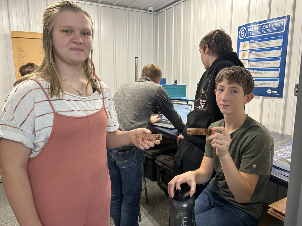 school board member teaching ag students about the laser engraver