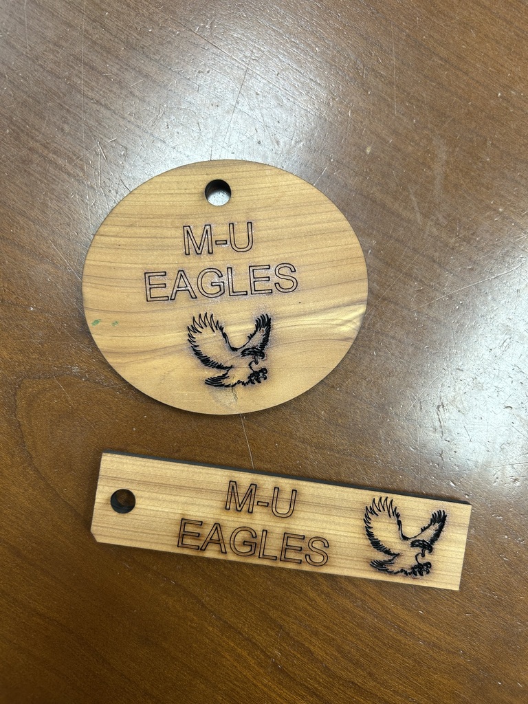 school board member teaching ag students about the laser engraver