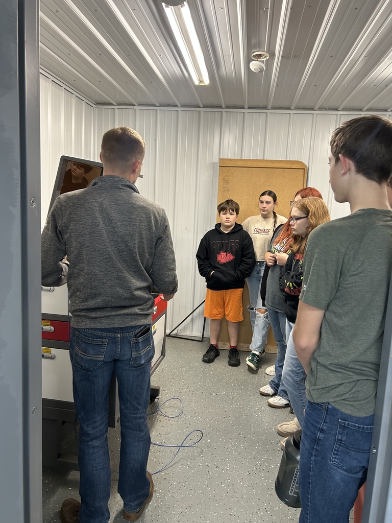 school board member teaching ag students about the laser engraver
