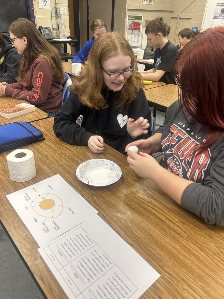 students cracking open eggs