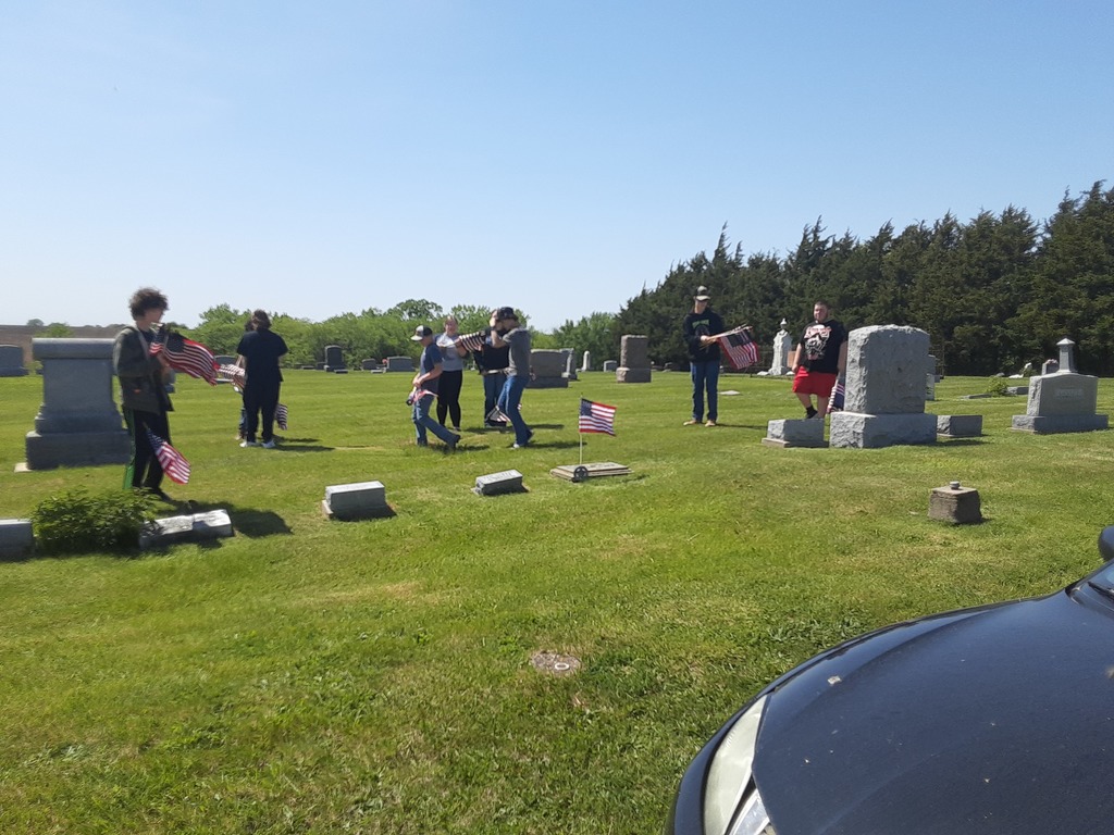 Moulton-Udell High School students doing their civic duty and good deed for the day by placing flags on veterans' graves at two cemeteries north of town on May 11th .