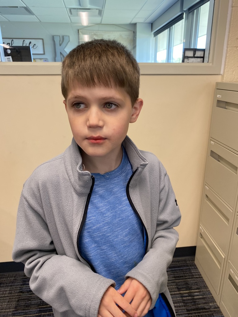 Boy wearing a blue shirt with a gray jacket