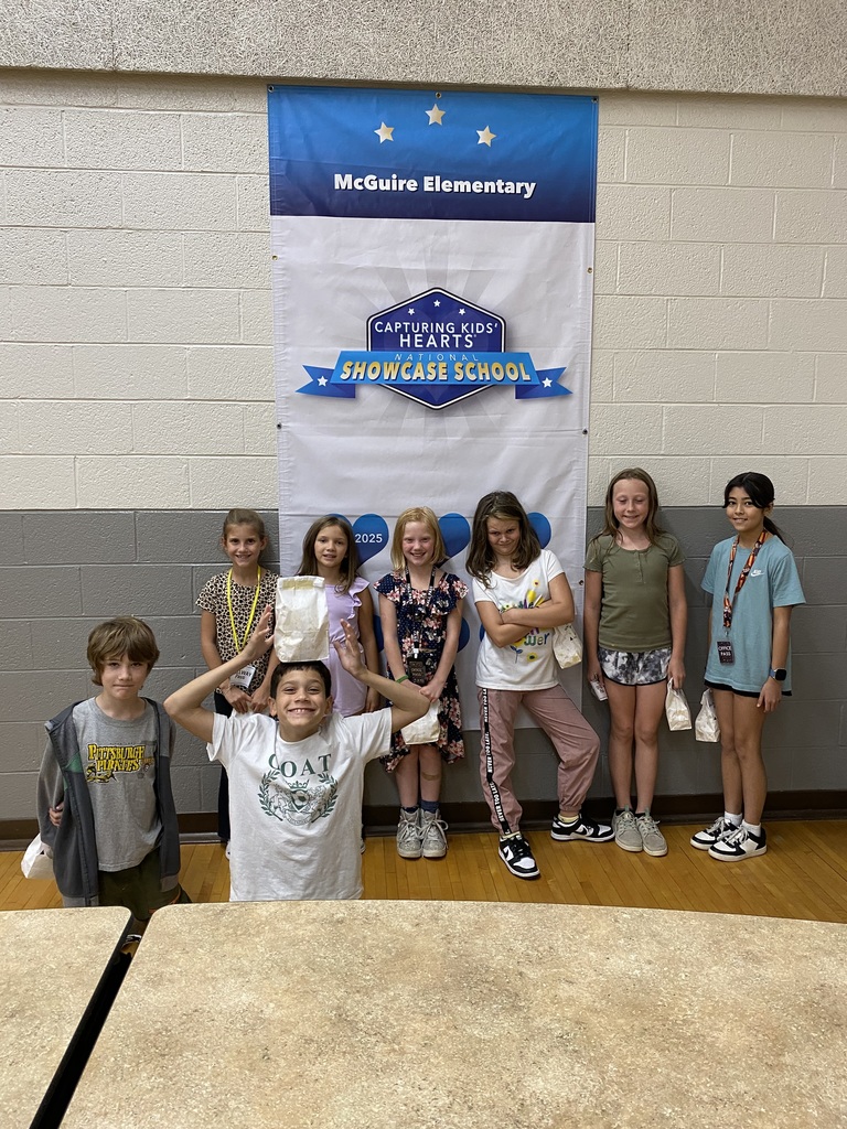 Group of students below a McGuire Elementary Showcase School sign
