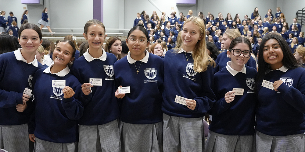 seven students holding small cards