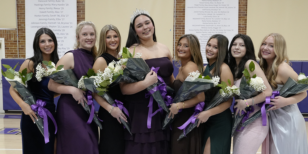 eight young women in formal gowns holding bouquets of flowers