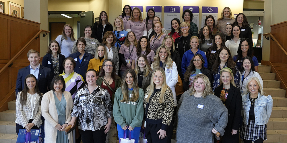 large group of people standing on staircase in building foyer