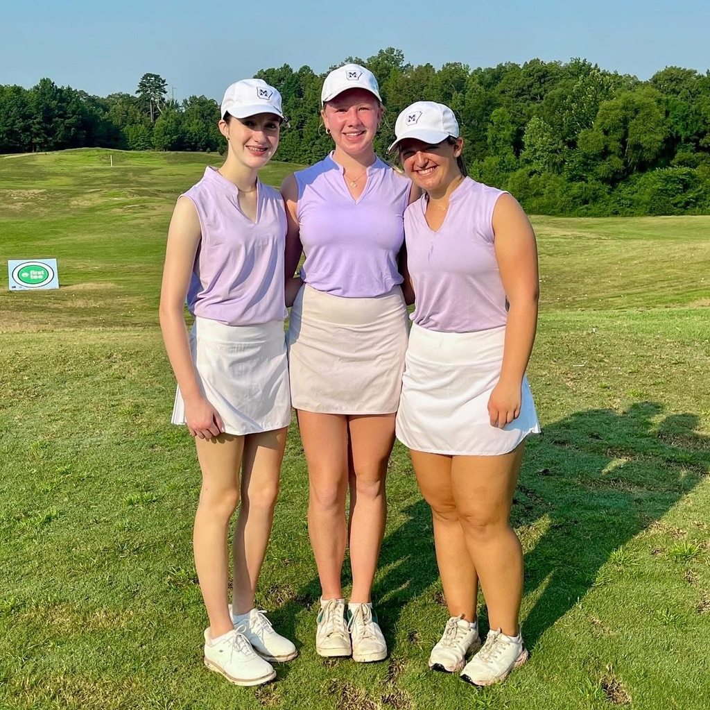 three female golfers standing on golf course smiling at camera