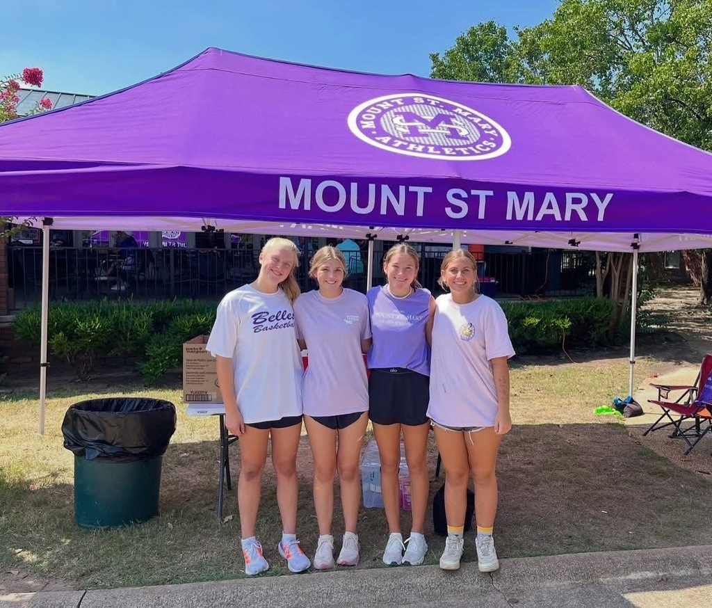five individuals standing outside in front of purple tent