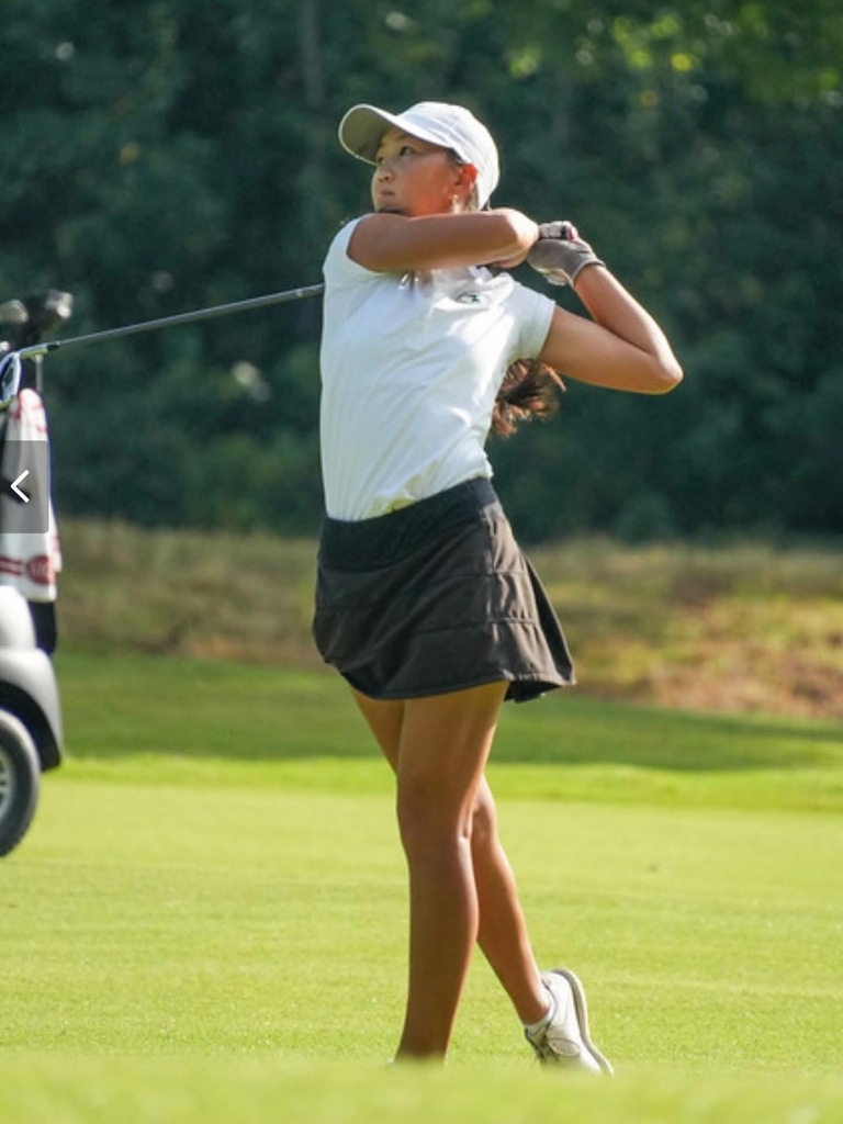 image of female golfer mid swing on golf course