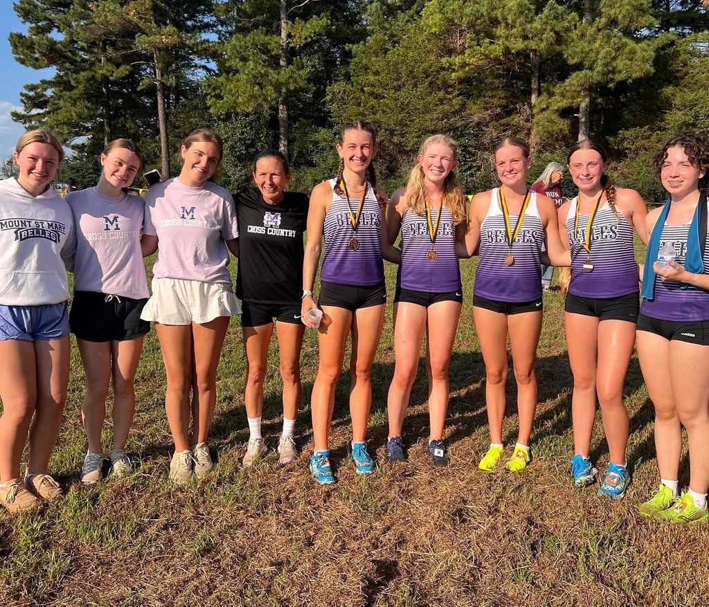 cross country runners and coach, all smiling at camera