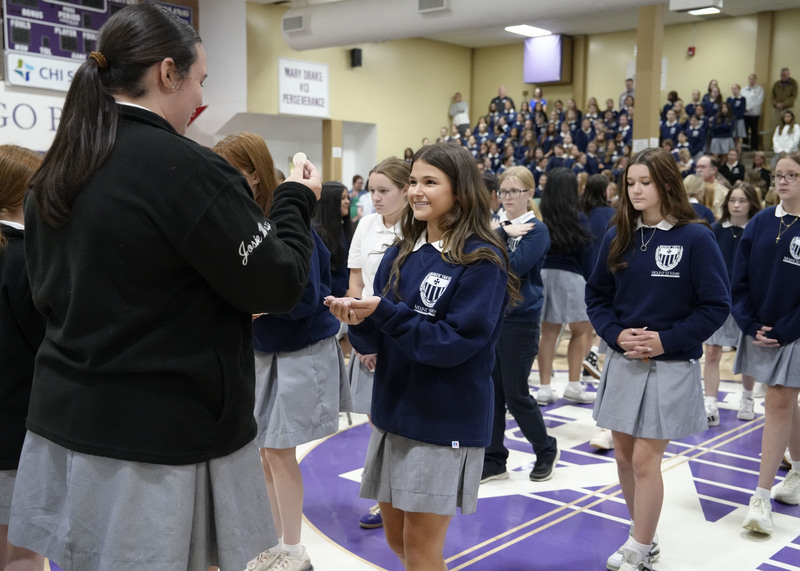 student receiving communion from a Eucharistic Minister during Opening School Mass