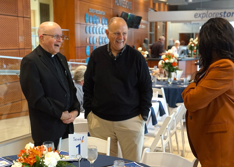 three individuals talking with one another around a table