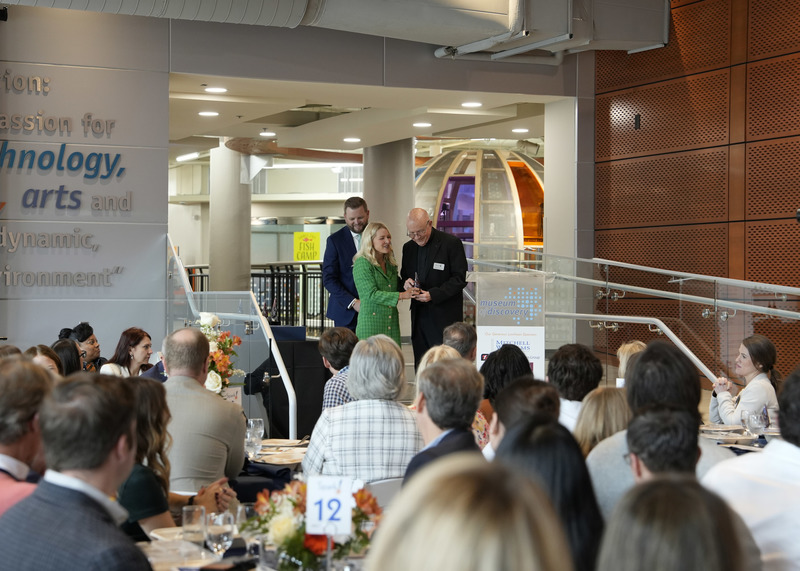 a man receiving an award as others look on