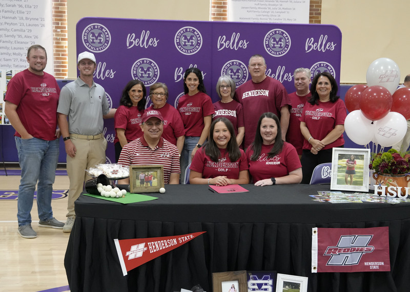 student athlete sitting at table surrounded by family